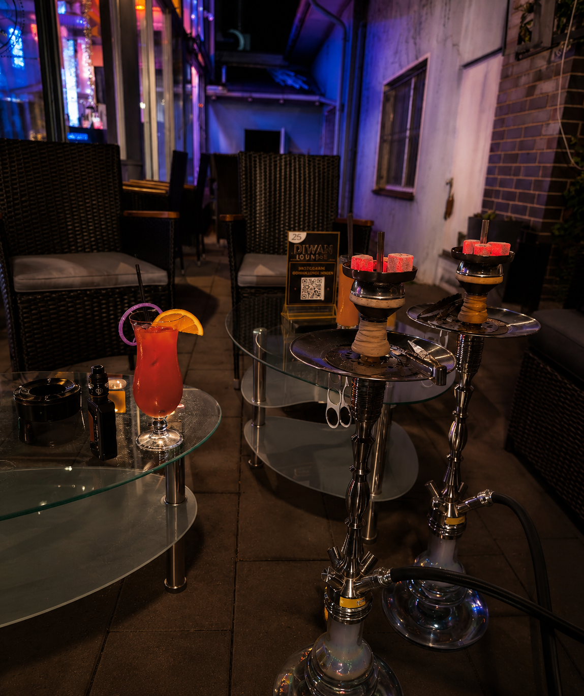 Terrasse der Diwan Lounge mit Shishas und Cocktail am Abend