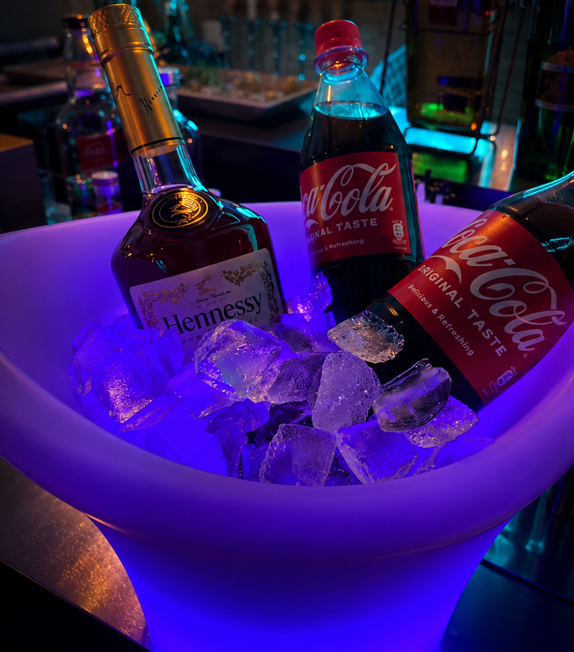 Hennessy mit Cola im leuchtenden Eiskübel an der Bar